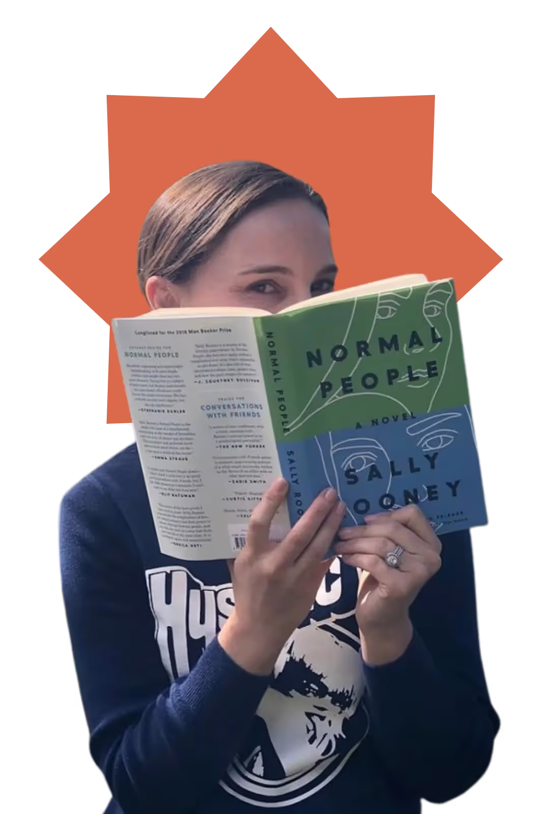 A woman reading a book with a green cover.